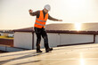 © dusanpetkovic1 - Laborer in protective uniform walking carefully on the roof with solar panels.