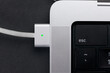 magsafe 3. Macbook pro 14 2022. magnetic charger charges laptop on black background. USB-C to MagSafe 3 Cable 