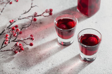 Two glasses of cherry liqueur on white background. Christmas or new year party celebration concept. Winter holidays concept.