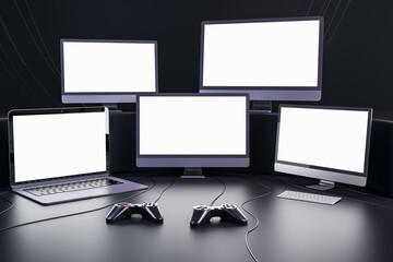 Poster - Streaming videogames and gaming concept with blank white glowing modern computer and laptops monitors with place for your text in dark empty room with joysticks on the floor. 3D rendering, mockup