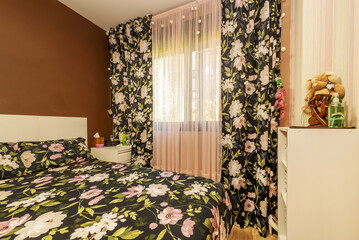 Sticker - Detail of a bedroom with white bookshelves and a loud bedspread with matching curtains