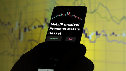 Wall Mural - Un inversor está analizando el metalli preziosi precious metals basket etf fondo en pantalla. Un teléfono muestra los precios del ETF para invertir. Texto en español.