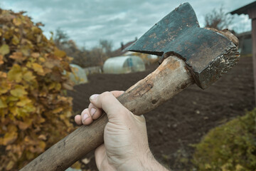 Old rusty axe with wooden handle stuck in the stump Large ax in hand