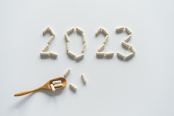 Vitamins on a white background. White Capsules form the new year 2023. Concept of health and new year.