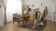 © PRPicturesProduction - full length of an asian househusband groaning in pain for he pulled his back muscles while cleaning the house with a vacuum cleaner in the living room at home.