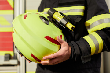 Close up image of a firefighter's helmet. Firefighter holding a yellow helmet