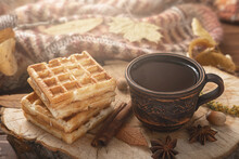 Brown Clay Cup Of Aromatic Herbal Tea With Spices Or Coffee And Sweet Pastries On Vintage Wooden Stand Table With Warm Woolen Blanket And Yellow Leaves. Concept Of Home Coziness, Hugge, Autumn Mood.