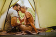 © Drobot Dean - White young couple smiling and hugging each other by tent in forest