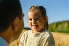 Happy Cute Girl With Father At Field On Sunny Day