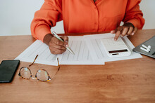 Businesswoman Calculating Financial Bills At Desk