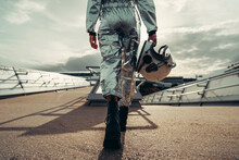 Hand Of Astronaut Holding Space Helmet Walking On Footpath