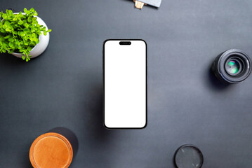 Aufkleber - Phone with isolated transparent display floats above the desk. The front camera is built into the display. Modern round and thin edges. Black table with plant, lens and box. Top view, flat lay