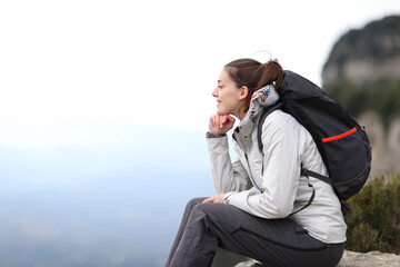 Wall Mural - Hiker contemplating mountain views from a cliff