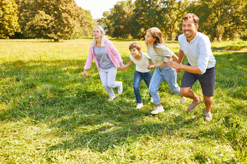 Wall Mural - Happy family runs across a green meadow