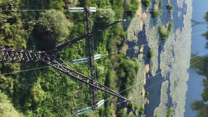 Wall Mural - Aerial view of high-voltage pylons with wires passing through wetlands.