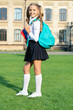 © be free - Happy girl carrying school bag and books. Teenage girl smiling in uniform. School education. Back to school