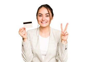 Young caucasian woman holding a credit card isolated on green chroma background showing number two with fingers.