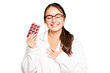 Young pharmacist woman holding a pills isolated on green chroma background laughs out loudly keeping hand on chest.