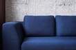 © brizmaker - blue modern couch on concrete wall background