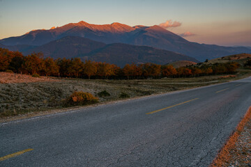Wall Mural - a paved, empty road in the massif of mount olympus in greece at sunset