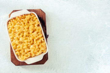 Wall Mural - Macaroni and cheese pasta in a casserole, shot from the top. Cheesy American comfort food, baked in the oven, with copy space