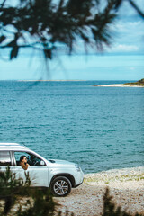 Wall Mural - woman in white suv car at sea beach. bay on background