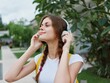 © SHOTPRIME STUDIO - Young woman portrait happiness travels on vacation with a backpack and headphones listening to music with a smile walking outside