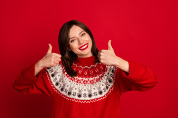 Poster - Photo of satisfied adorable gorgeous girl with straight hairstyle wear red sweater showing thumb up isolated on red color background