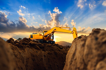 Wall Mural - Crawler excavator  are digging  soil in the construction site on the blue sky and sunset  backgrounds