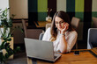 © andriyyavor - Beautiful woman working on her laptop and phone on a stylish urban restaurant
