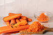 Grated carrots and grater on the table. Cook at home.