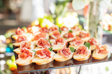 catering buffet table with snacks and appetizers. Set of canapés with jamon, bruschetta and cheese