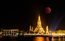BANGKOK, THAILAND - November 8, 2022 : Lunar Eclipse, 
Super Red Full Moon Taken From Top Side Of “Wat Arun Temple”, 
This Is A Wonderful Natural Phenomenon With The View Along Chao Praya River.