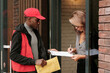 © pressmaster - Young black man in uniform holding envelope with letter while businesswoman with pen signing delivery document held by courier