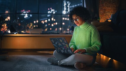 Aufkleber - Beautiful Authentic Latina Female Sitting on the Floor in a Cozy Living Room and Using Laptop Computer at Home. She's Browsing the Internet and Checking Videos on Social Networks.