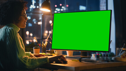Poster - Creative Black Woman Sitting at Her Desk, Using Desktop Computer with Mock-up Green Screen Chromakey. Female Specialist Using Mouse, Scrolling Through Objects, Adding New Elements. Freelance Concept.