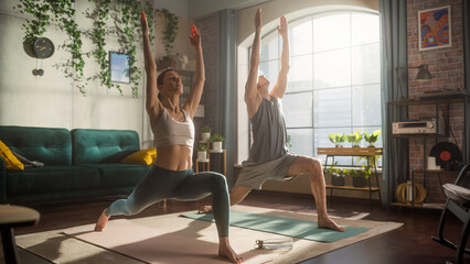 Wall Mural - Athletic Young Couple Exercising Together, Stretching and Doing Yoga in the Morning in Bright Sunny Room at Home. Beautiful Man and Woman in Sports Clothes Practising Different Asana Poses on the Mat.