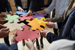 © Studio Romantic - Group of business people connecting red, yellow, orange, green, blue and purple jigsaw puzzle parts. Corporate team suggesting different creative ideas. Cropped close up. Teamwork, innovation concept