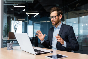 Online meeting, mature businessman inside office talking remotely online with colleagues and partners, video call senior male executive using laptop to communicate.