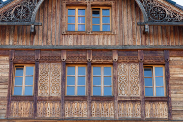 Wall Mural - Windows on the wooden facade of a rustic house made of wooden beams in a mountains Carpathian village, Western Ukraine, Europe