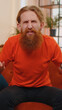 © Andrii Iemelianenko - What. Why. Portrait of caucasian bearded man raising hands in indignant expression, asking reason of failure demonstrating disbelief irritation by troubles. Young guy at home on orange couch. Vertical