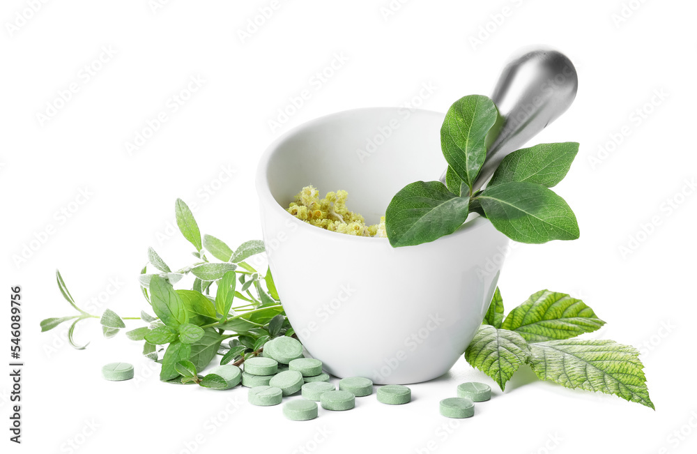Mortar with different herbs and pills on white background