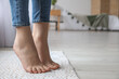 © Pixel-Shot - Female bare feet on rug in room, closeup