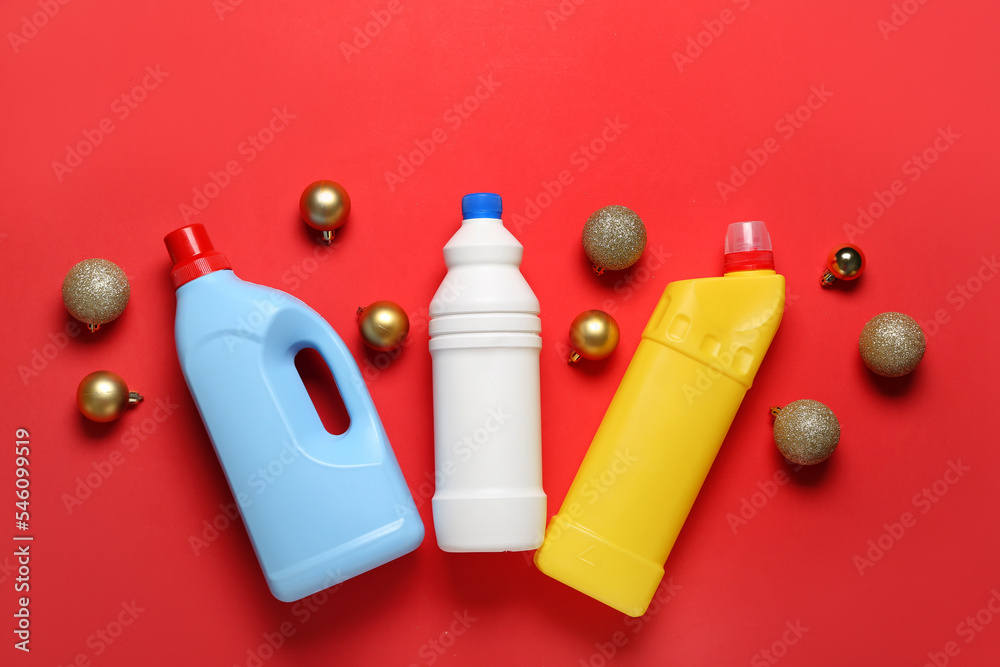 Bottles of detergent with Christmas balls on red background