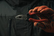 man's hand holding a black and red wire cutter plier open ready to cut form