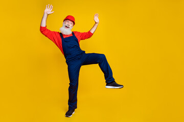 Poster - Full length photo of careless funny senior foreman with white beard red helmet hands up scream isolated on yellow color background