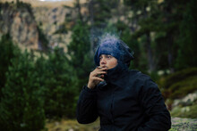 Boy With Coat And Hat Smoking A Marijuana Cigarette In Nature