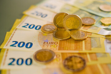  euro coins and banknotes on a green background.Expenses and incomes in European countries. Finance and savings.Cash payments and expenses.Euro currency.