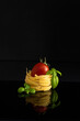 Ingredients of Italian pasta with basil and tomato on a black background. Close-up
