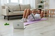 © SHOTPRIME STUDIO - Man sports, watching tape of workout on phone and repeating exercises sports blogger with laptop training online, pumped up man fitness trainer works out at home, the concept of health and body beauty